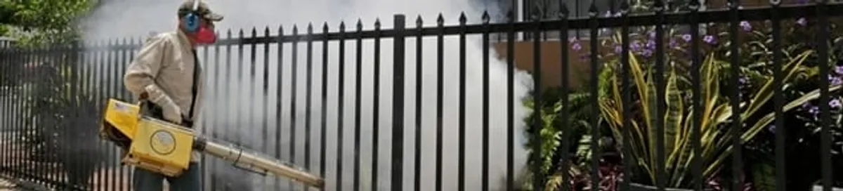 Mosquito control technician fogging a yard perimeter for mosquito reduction in Baltimore, MD